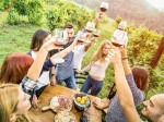 Young friends having fun outdoors drinking red wine glasses - Happy people eating seasonal local food at harvest time in farmhouse vineyard winery - Youth friendship concept on warm vintage filter